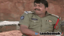 a man in a military uniform is holding a stick in front of his face and the words iamhemuk are on the bottom right