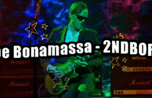 a man playing a guitar in front of a banner that says " joe bonamassa - 2ndbof "