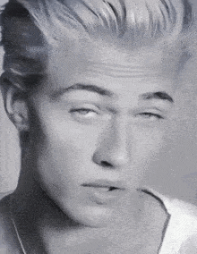 a black and white photo of a young man with his eyes closed .