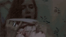 a woman is laying in bed with a pink blanket on her face .