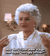an older woman wearing a sign that says too ugly to live