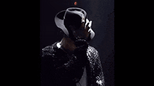 a close up of a person wearing a black hat and a white ribbon .