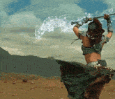 a woman in a green dress is holding a sword in a desert