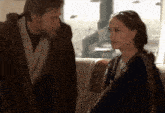 a man and a woman are looking at each other
