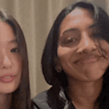 two women are posing for a picture and smiling for the camera .