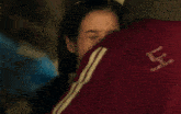a person wearing a red shirt with the letter j on it