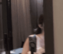 a woman standing in front of a mirror holding a camera