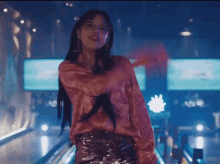 a woman wearing glasses and a pink shirt is dancing on a bowling alley