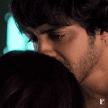 a close up of a man kissing a woman 's forehead with the letter z visible