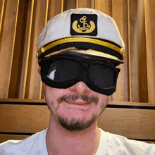 a man wearing a captain 's hat with an anchor on it