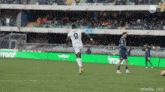a soccer player wearing a number 9 jersey kicks the ball
