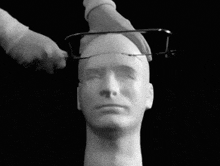 a person is cutting a man 's head with a saw