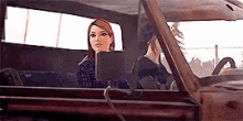 a woman is sitting in the back seat of a truck .