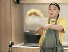 a man wearing an apron is cleaning a microwave