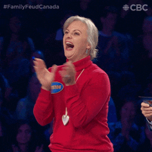 a woman wearing a red sweater with the name chris on it clapping