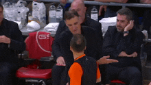a man talking to another man in front of a chair with a gs logo on it
