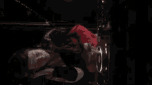 a woman in a red sweater is laying on her back in front of a speaker .