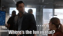 a man in a suit is standing next to a woman in a red shirt and says where 's the fun in that ?