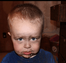 a young boy with a dirty face is wearing a blue shirt with a pittsburgh steelers logo on it