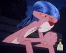a pink panther is wearing a blue headband and sitting next to a bottle of tequila .