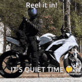 a man riding a motorcycle with the words reel it in it 's quiet time
