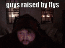 a man 's face is projected onto a wall with the words " guys raised by flys "