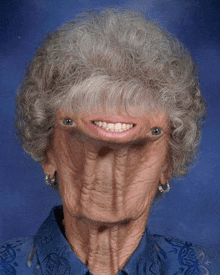 a woman with gray hair and a blue shirt has a face that looks like a monster