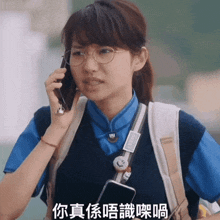 a girl wearing glasses is talking on a cell phone with chinese writing on the bottom