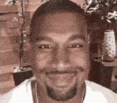 a man with a beard and a white shirt is smiling .