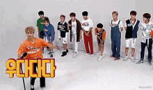 a group of young men are standing in a line and one of them is wearing an orange shirt that says medalist