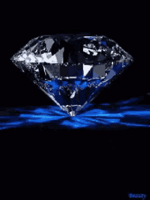 a large diamond is sitting on top of a blue surface .