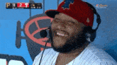 a man wearing a red hat and headphones is laughing