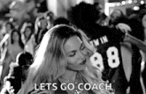 a black and white photo of a woman dancing in a crowd with the words `` let 's go coach '' .