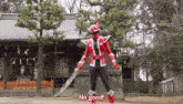 a man in a red and black costume is holding a sword and says " no good "