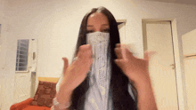 a woman wearing a mask with fringe is giving a middle finger