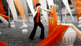 a man in an orange shirt is dancing with a woman