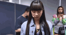 a girl with long hair is standing in a room with a microphone in her hand .