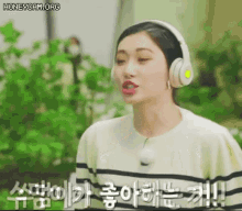 a woman wearing headphones and a striped shirt is talking to someone .
