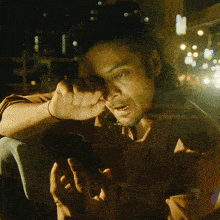 a man with long hair is looking at a cell phone in a dark room