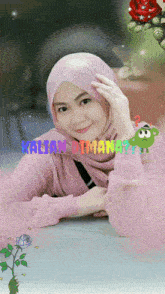 a woman wearing a pink sweater and a pink hijab with the words kalian dimana