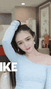 a woman in a blue off the shoulder top with the word like on the bottom