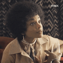 a woman sitting at a table with a max logo on the bottom right