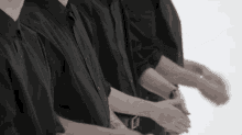 a group of people in black shirts are clapping their hands together