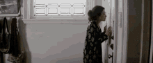 a woman looking through a door with a stained glass window