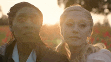 two women standing next to each other in a field
