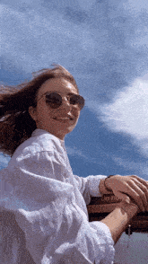 a woman wearing sunglasses is standing in front of a sign that says do not