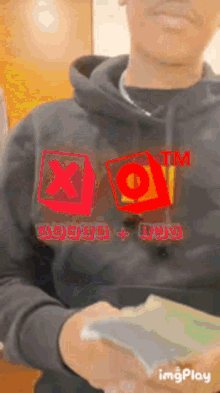 a man in a black hoodie is holding a bunch of money