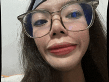 a woman wearing glasses and a beanie makes a funny face