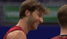 a man wearing a red tank top that says vnl on the back