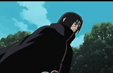 a man in a black cape is standing in front of a forest .
